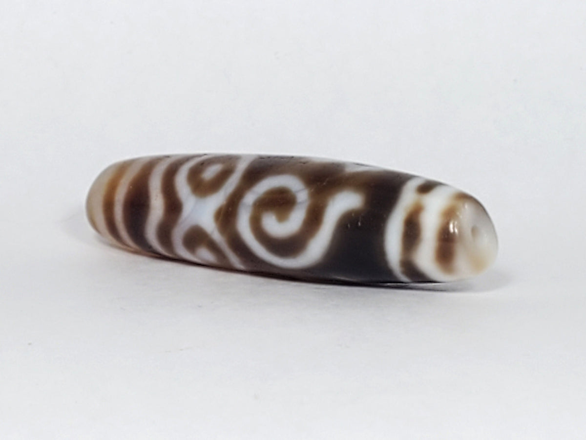 At-061926-PDEBS angled tip B, honey-tan cap, small drill hole, scroll detail visible, unretouched