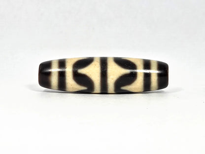 Antique Tibetan double wave dzi bead (AT-092826-DW2), first lateral profile showing bold black double wave forms in three panels on cream-white agate ground, 40.4 mm, 200–400 years old