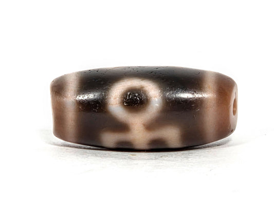 Benefactor Variant V-071426-BNF 27.4×12.2mm dark brown agate face A — eye upper centre, arms-down motif, unretouched.
