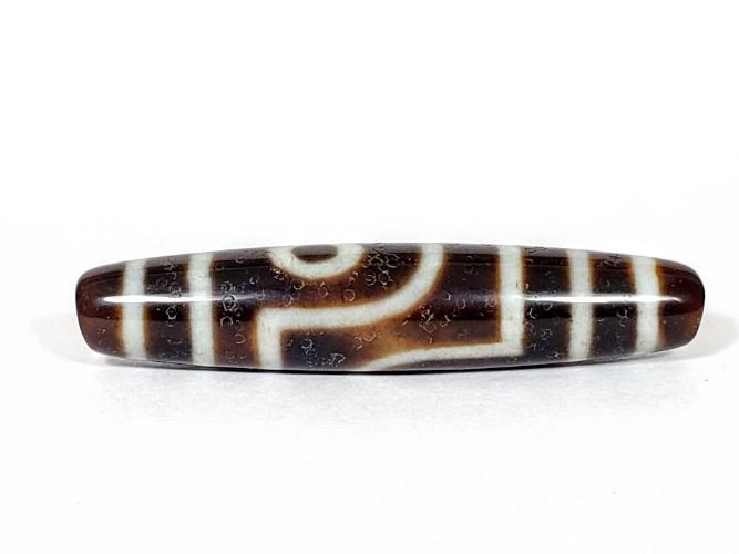 A vintage Dzi bead with a captivating Two Eye Motif. This authentic artifact showcases the timeless beauty and cultural significance of ancient Dzi bead