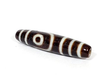 A vintage Dzi bead with a captivating Two Eye Motif. This authentic artifact showcases the timeless beauty and cultural significance of ancient Dzi bead