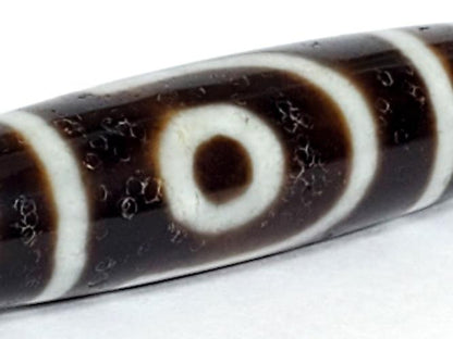 A vintage Dzi bead with a captivating Two Eye Motif. This authentic artifact showcases the timeless beauty and cultural significance of ancient Dzi bead