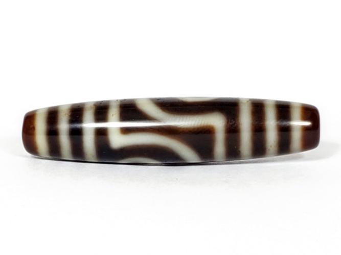 A vintage Dzi bead featuring a unique Two Eye Motif and a rare Triple Bar design. This rare find showcases the intricate craftsmanship and symbolic beauty of ancient Dzi beads
