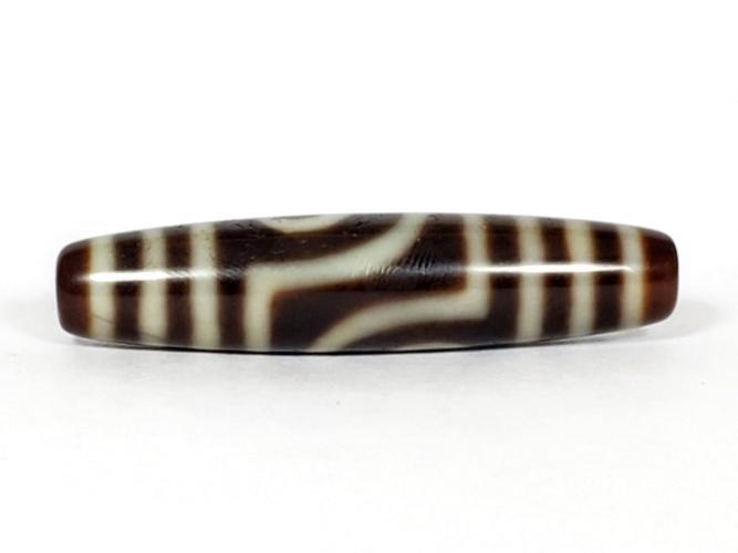 A vintage Dzi bead featuring a unique Two Eye Motif and a rare Triple Bar design. This rare find showcases the intricate craftsmanship and symbolic beauty of ancient Dzi beads