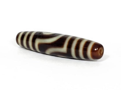 A vintage Dzi bead featuring a unique Two Eye Motif and a rare Triple Bar design. This rare find showcases the intricate craftsmanship and symbolic beauty of ancient Dzi beads