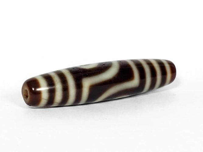 A vintage Dzi bead featuring a unique Two Eye Motif and a rare Triple Bar design. This rare find showcases the intricate craftsmanship and symbolic beauty of ancient Dzi beads
