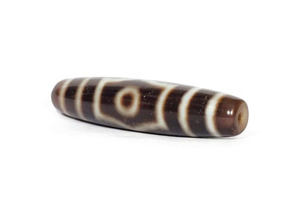A vintage Dzi bead with a captivating Three Eye Motif. This authentic artifact, identified as TD-ThE-003, showcases the spiritual significance and timeless allure of ancient Dzi beads."