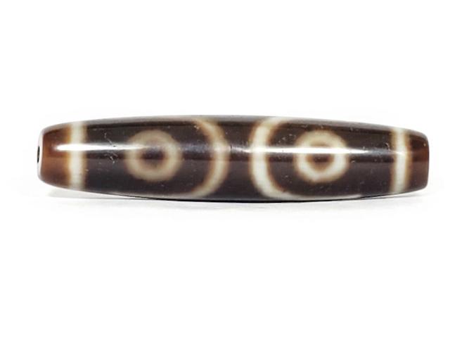 A vintage Dzi bead with a mesmerizing Three Eye Motif. This authentic artifact, identified as TD-ThE-003, showcases the intricate craftsmanship and spiritual symbolism of ancient Dzi beads.