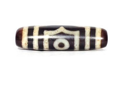 A vintage Dzi bead featuring a rare triangular shape and a captivating Three Eye Motif. This authentic artifact showcases the unique design and spiritual symbolism of ancient Dzi beads
